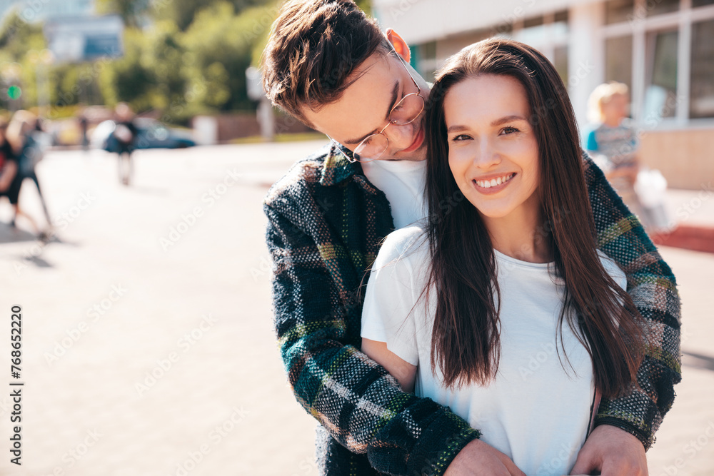 Smiling beautiful woman and her handsome boyfriend. Woman in casual summer clothes. Happy cheerful family. Female having fun. Sexy couple posing in the street at sunny day