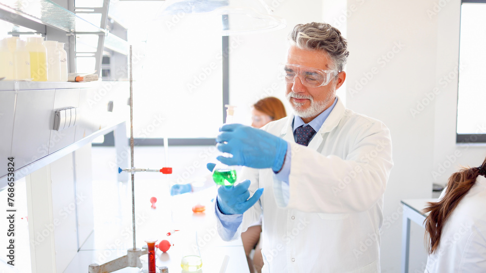 Mature lab specialist working on some chemical samples at his ...