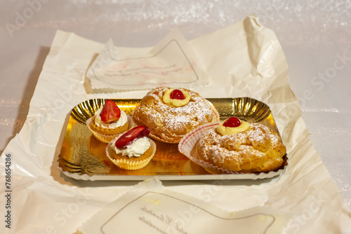 Italian dessert Zeppole di San Giuseppe, zeppola baked puffs made from choux pastry, filled and decorated with custard cream and cherry. photo