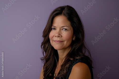 Portrait of a beautiful middle-aged woman on a purple background
