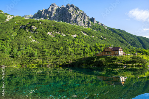 Mountain cottage reflecting in the lake. Chata pri Zelenom plese in High Tatras mountains, Slovakia