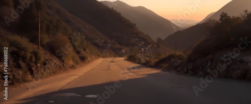 Low-level view of an empty old paved road in a mountain area at sunset 