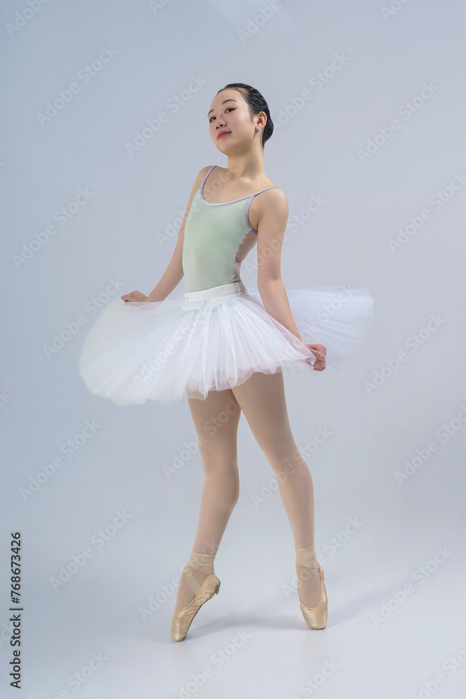 young Japanese ballerina poses in a photo studio with ballet elements showing stretching and plasticity young Japanese ballerina poses in a photo studio with ballet elements showing stretching and plasticity