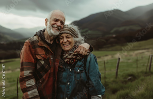 photo of happy senior couple hugging each other and laughing in the green field