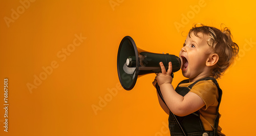 kid with curly hair on yellow background with megaphone © Gita