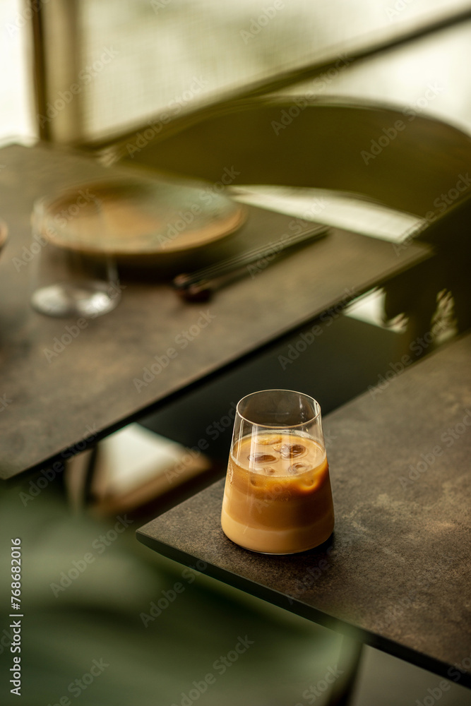 Glass of iced coffee in a minimalist coffee shop. Minimalist style. Glass of iced coffee in a minimalist coffee shop. Minimalist style.