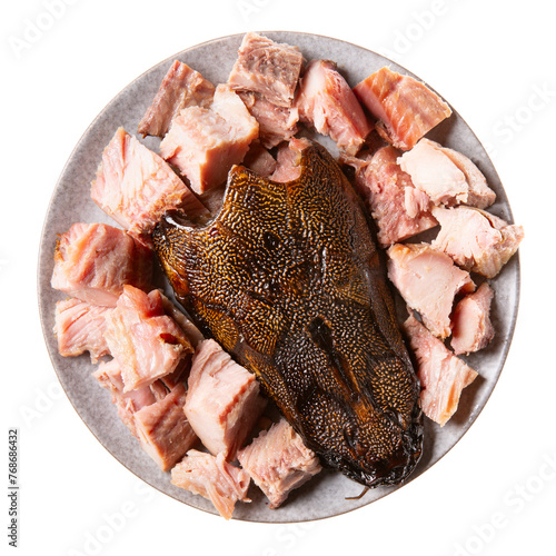 Hot smoked african catfish (Clarias gariepinus). Fish pieces on gray plate isolated on white background. Top view.