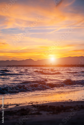 beautiful sunset over calm sea, waves of water and clean sand, Salou, Spain