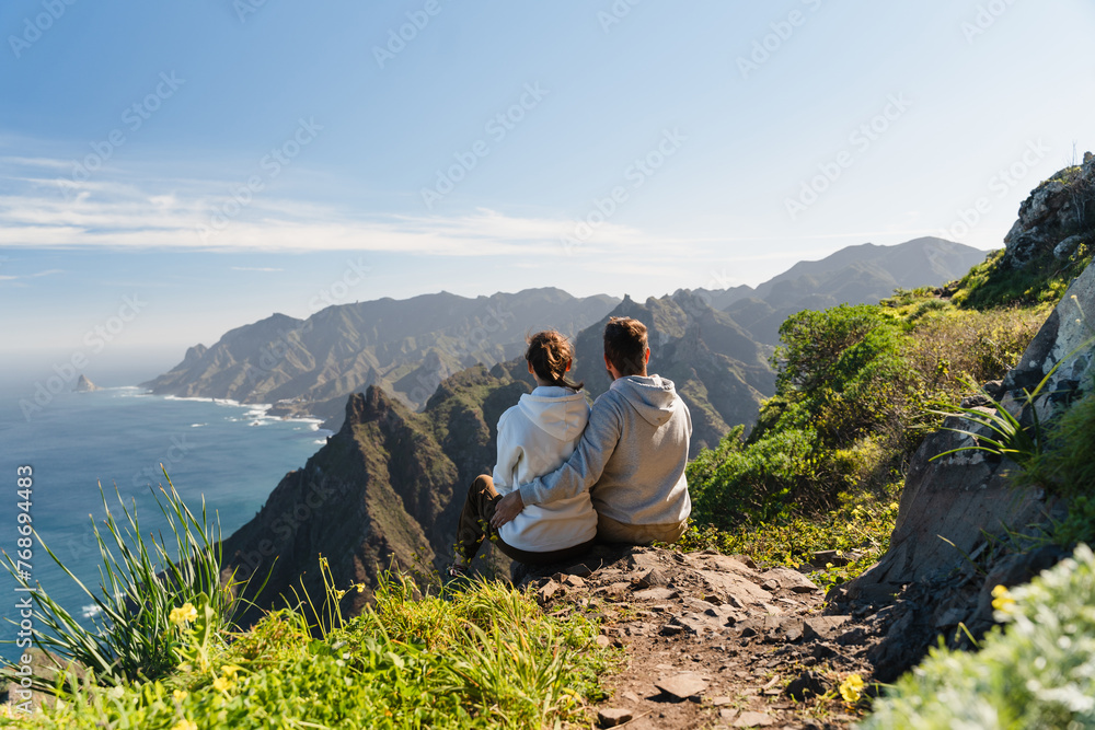 Couple enjoying vacation in nature. Hikers watching beautiful coastal scenery.