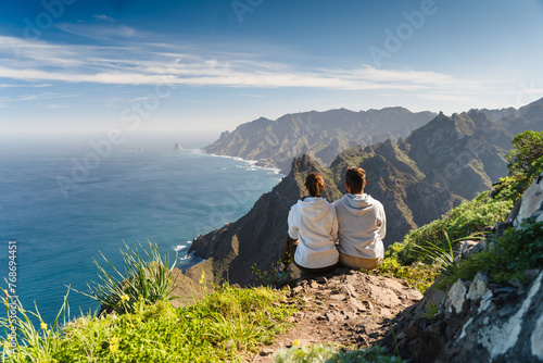 Couple enjoying vacation in nature. Hikers watching beautiful coastal scenery.