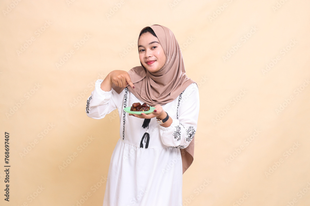 Fototapeta premium a beautiful indonesia Muslim woman wearing a hijab was surprised to bring dates for sahur and breaking the fast. used for advertising, health, Eid and Ramadan
