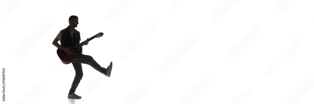 Silhouette of man cheerfully playing guitar isolated on white background. Black and white image. Concept of music, festival, concert, entertainment, instruments. Banner, empty space for ad Silhouette of man cheerfully playing guitar isolated on white background. Black and white image. Concept of music, festival, concert, entertainment, instruments. Banner, empty space for ad