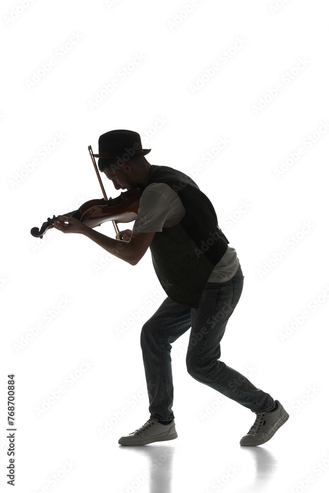 Male silhouette, musician playing violin isolated on white background. Black and white image. Classic music. Concept of music, festival, concert, entertainment, instruments. Poster, ad Male silhouette, musician playing violin isolated on white background. Black and white image. Classic music. Concept of music, festival, concert, entertainment, instruments. Poster, ad