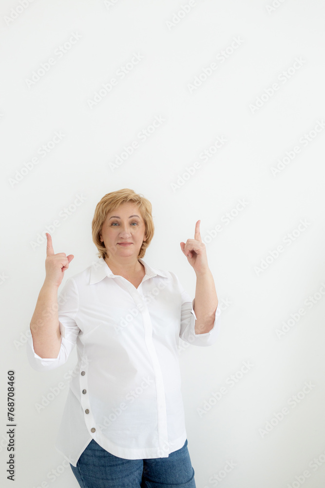 Smiling confident middle aged business woman points with hands to space for text on white background. Old senior businesswoman, 60s professional female manager, leader looking at camera, copy space Smiling confident middle aged business woman points with hands to space for text on white background. Old senior businesswoman, 60s professional female manager, leader looking at camera, copy space