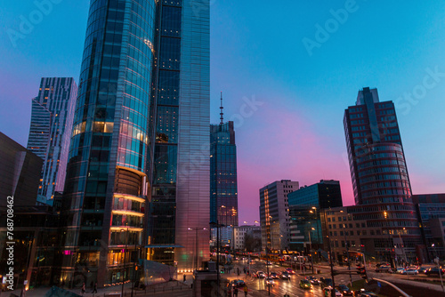Beautiful modern city of Warsaw with buildings and road on the evening sunset sky with blue and pink light. Poland © alones