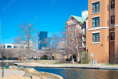 Hotels, buildings along Bricktown canal with downtown Oklahoma City skyline background, riverside restaurants, tourist attractions in Entertainment District, travel destination, water taxi photo