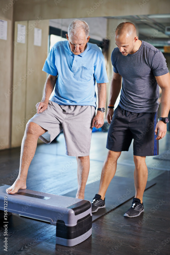 © peopleimages.com - Physiotherapist, helping and senior man with cardio, training and elderly support for care. Men, gym and exercise for health, wellness and coaching with aerobic step for mature rehab and wellbeing © peopleimages.com - Physiotherapist, helping and senior man with cardio, training and elderly support for care. Men, gym and exercise for health, wellness and coaching with aerobic step for mature rehab and wellbeing