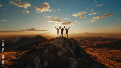 Together overcoming obstacles with three people holding hands up in the air on mountain top ,  photo