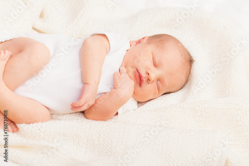Newborn Baby Asleep on Cream Blanket
