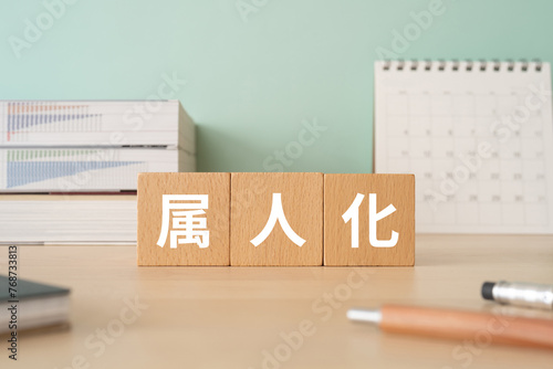 属人化の文字が入ったブロックが置かれたデスク