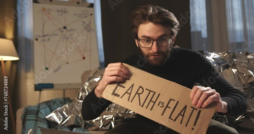 Pseudoscience and conspiracy theory. A man in a tinfoil hat proves the flat earth theory.