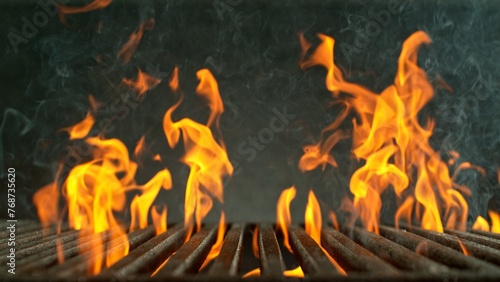 Close-up of cast-iron grate with fire flames, dark background