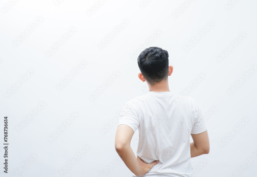 rear view of an asian man touching his back in pain
