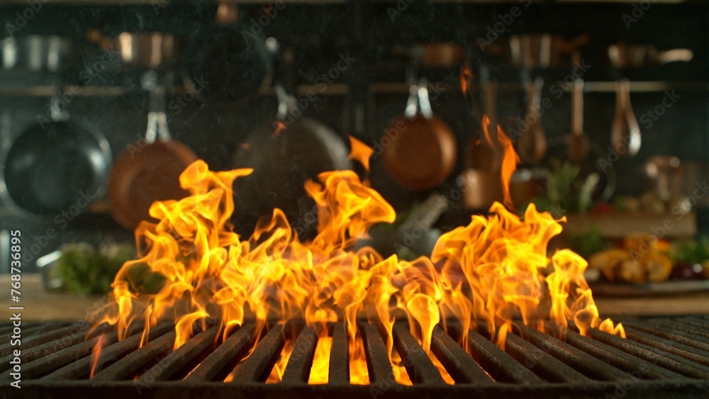 Obraz premium Close-up of cast-iron grate with fire flames, dark background