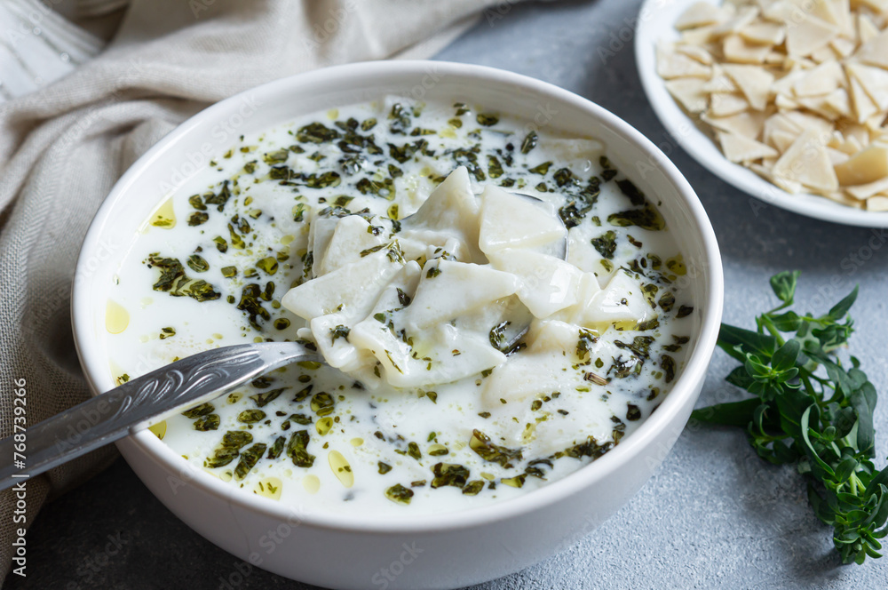 Traditional turkish homemade triangular cut yoghurt dough soup with oil and dried mint leaves Traditional turkish homemade triangular cut yoghurt dough soup with oil and dried mint leaves