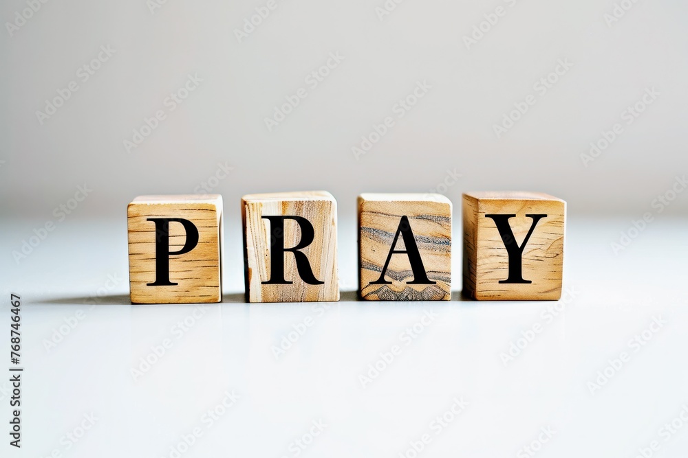 Obraz premium PRAY text on the wooden block, wooden cubes on white background with copy space, religion concept space for text