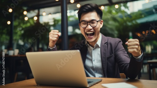 Excited Asian Businessman Celebrating Success or Deal Agreement at Desk Generative AI