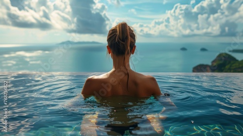 Woman Sitting in Pool, Looking at Ocean