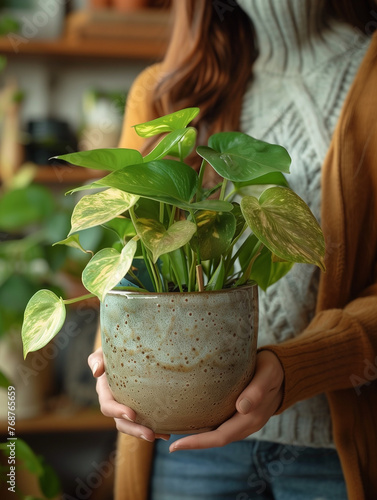 Unrecognizable woman carrying a houseplant