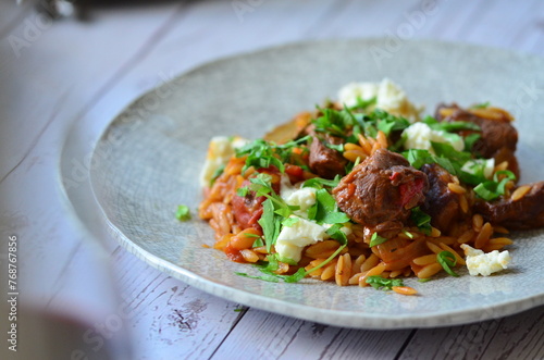 lamb stewed with tomatoes and orzo, background of greek traditional food youvetsi photo