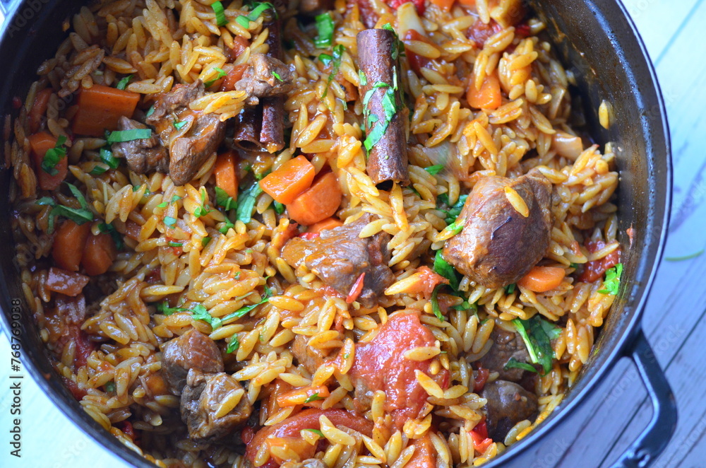 Rice with lamb meat and vegetables on a plate on a wooden table Rice with lamb meat and vegetables on a plate on a wooden table