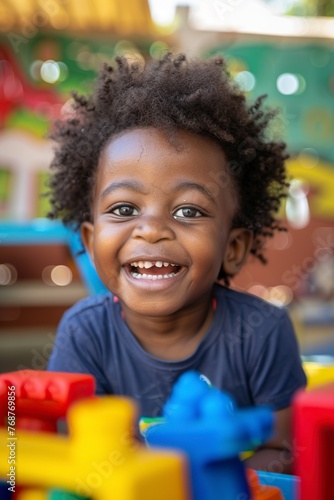 Young Boy Smiling in Front of Toys