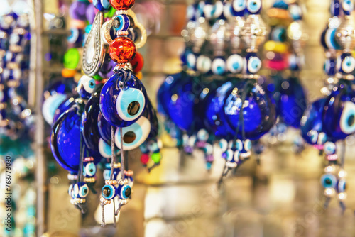 Evil eye amulets in a deep cobalt blue, symbolizing protection, dangle amongst trinkets in a Turkish market. Istanbul, Turkey (Turkiye)
