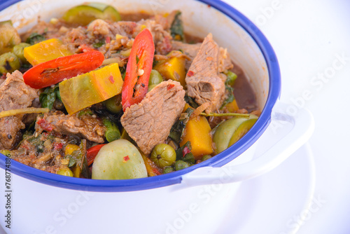 Thai favorite food. Spicy pork soup (Tom Yum Mhu Baan) in the white bowl.