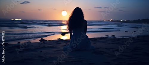 A woman seated on the shore...