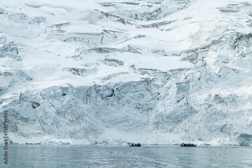 Tourist boats are dwarfed by a glacier in Northern Svalbard