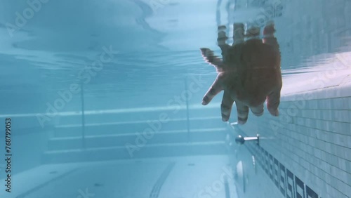 Female Hand Moving with Reflection Underwater in Swimming Pool in Switzerland.  photo