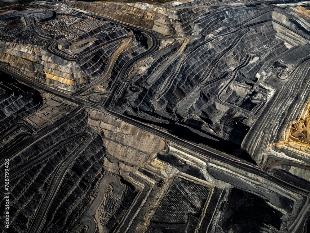 a massive dirt pit with lots of coal on it and two other smaller piles a massive dirt pit with lots of coal on it and two other smaller piles