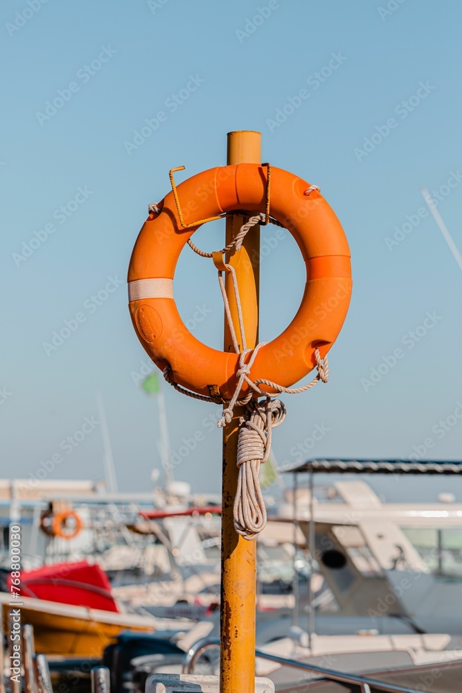 Orange lifeguard ring on a metallic pole