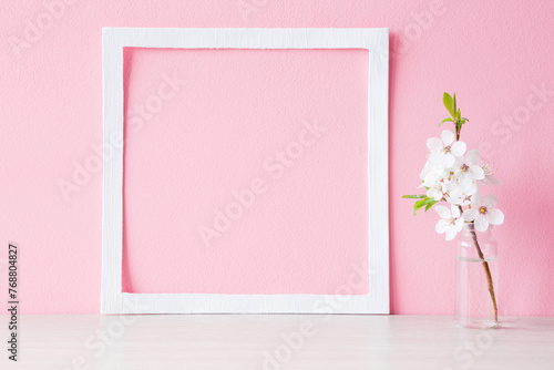 Fresh branch of white cherry blossoms in glass vase on table at light pink wall background. Pastel color. Empty place for inspirational text, lovely quote or sayings in frame. Closeiup. Front view. © fotoduets