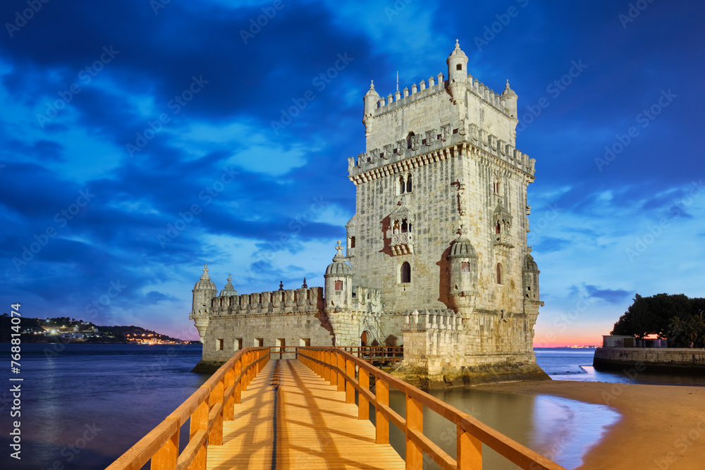 Naklejka premium Belem Tower or Tower of St Vincent - famous tourist landmark of Lisboa and tourism attraction - on the bank of the Tagus River (Tejo) after sunset in dusk twilight with dramatic sky. Lisbon, Portugal