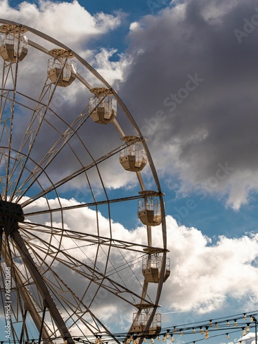 a ferris wheel on the side of a road under blue skies photo