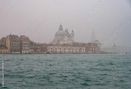 Skyline of Venice on a foggy day with Santa Maria della Salute in the foreground. © Wirestock