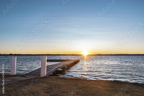 View of Tuggerah Lake in Toukley, Central Coast, NSW, Australia at sunset, with a jetty jutting out photo