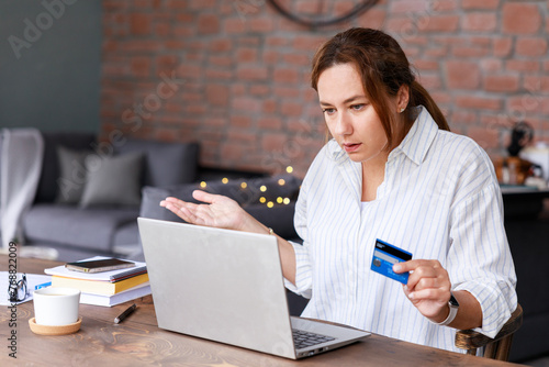 Young woman have problems with her credit card during shopping online