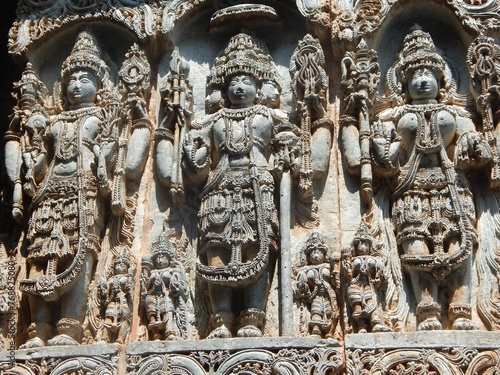 Intricately carved stone statues of Hindu gods adorning the Hoysaleshwara Temple in Halebedu, India photo
